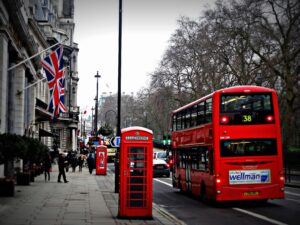 Insights Classic London scene featuring a red double-decker bus and iconic phone booth on a busy city street.